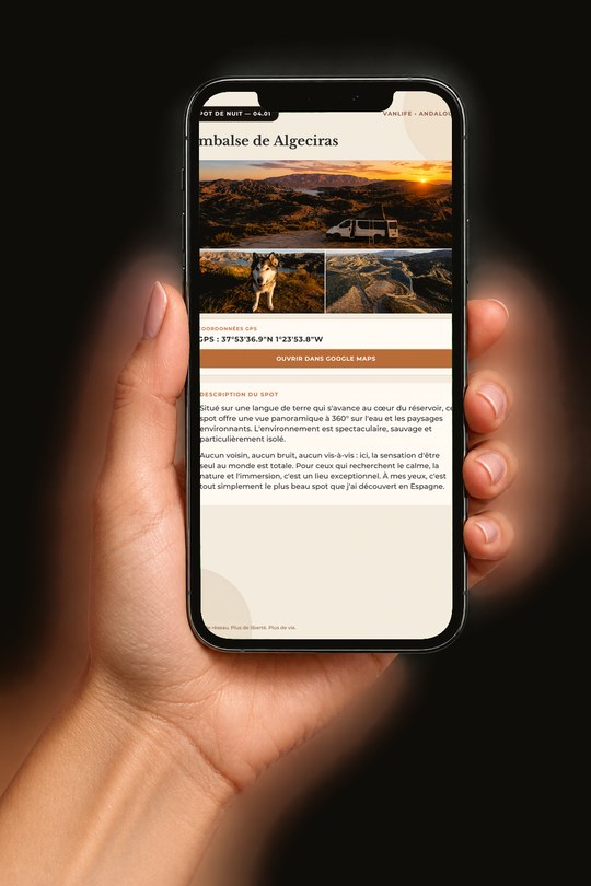 Une main tenant un téléphone qui affiche une page du guide